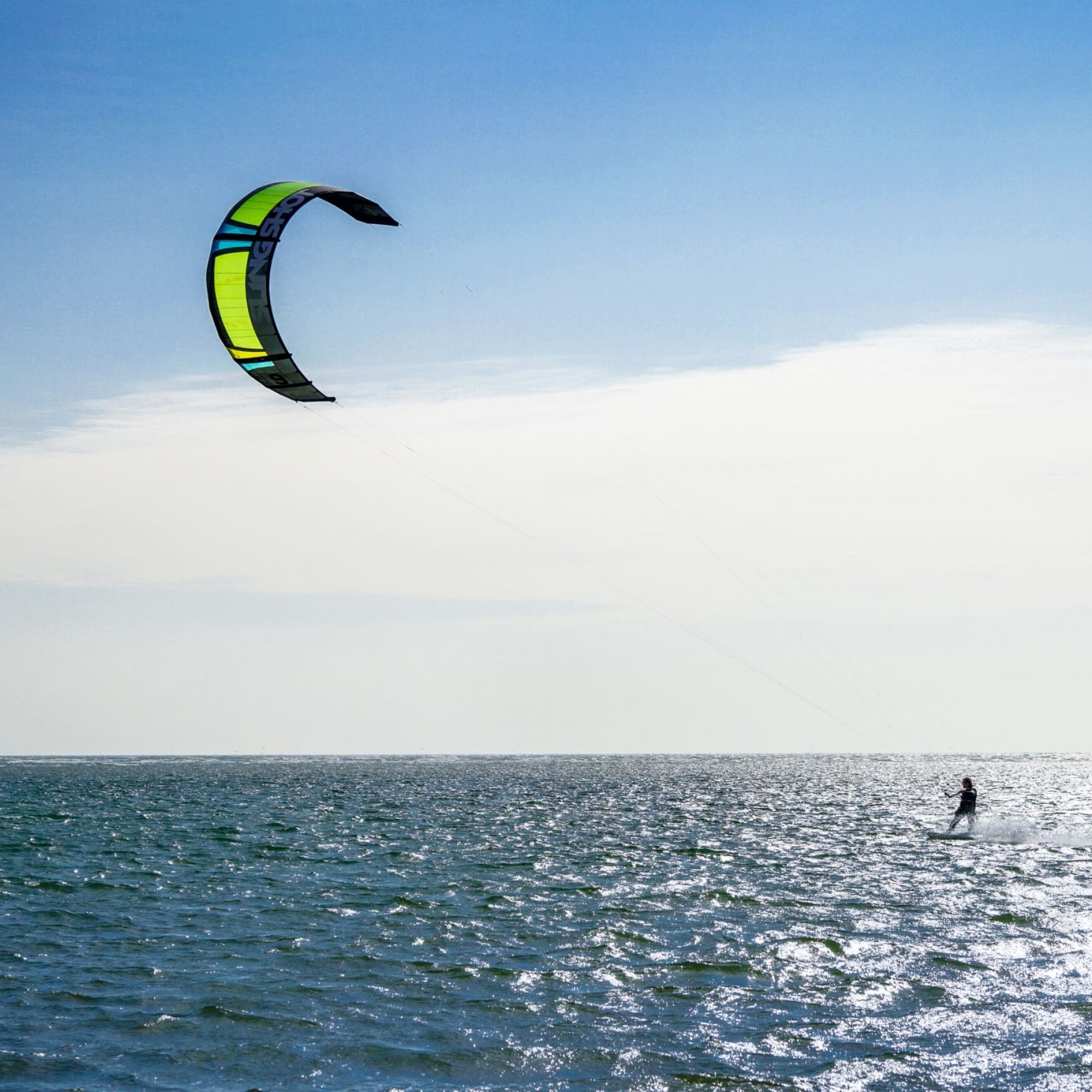 Kitesurfen-gruener-Kite-auf-Meer